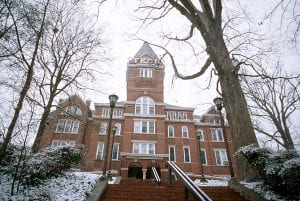 Photograph of Tech Tower in the winter. Snow covers the shrubs along the sides of the brick steps leading up to the building.